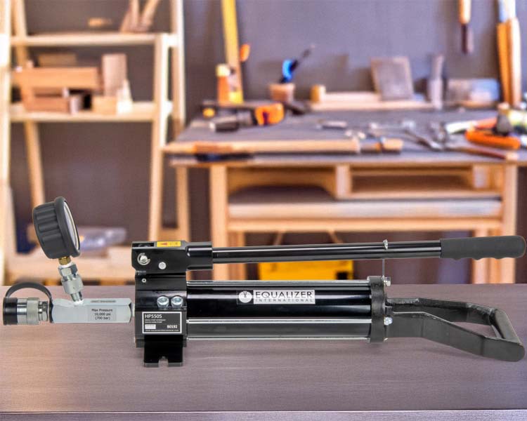 Enerpac HP series hand pump sitting on a work bench, showcasing its robust design.