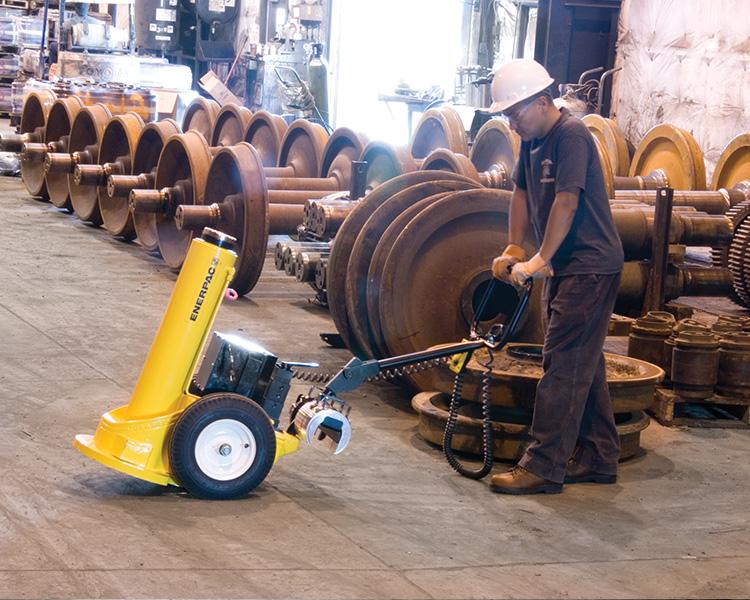 A construction worker wearing a hard hat, safety vest, and tool belt stands confidently next to a yellow featherlite ladder in a bright indoor setting.