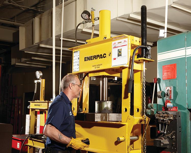 Workers monitor aluminum beams with featherlite labels moving on an industrial assembly line in a manufacturing facility.