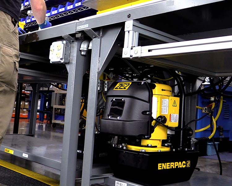 Pompe ZE2 d’Enerpac sous une table dans un poste de travail.